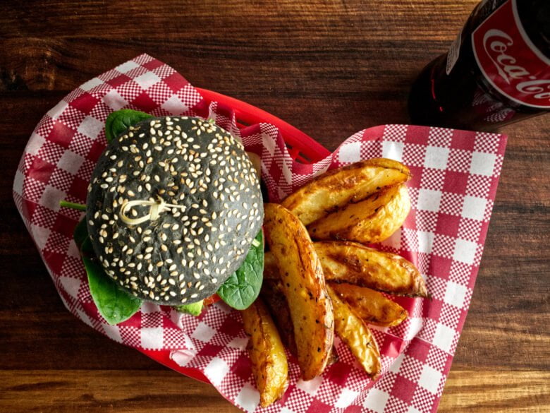 Kangaroo burgers with potato wedges served in a red diner basket