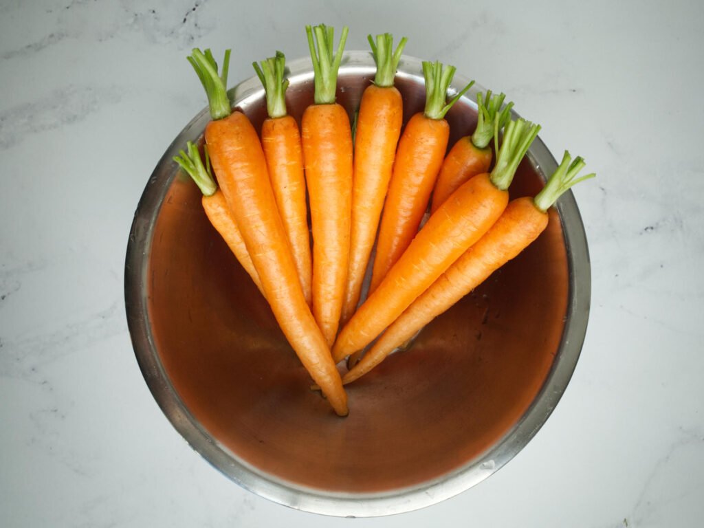 Trimmed Dutch carrots in kitchen bowl