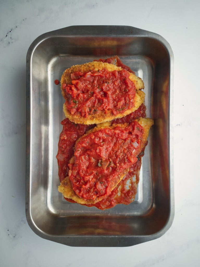 Chicken schnitzels covered in tomato sauce