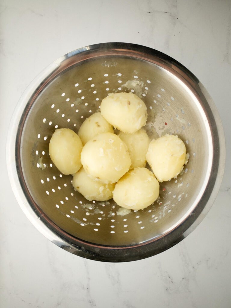 Boiled potatoes roughed up in colander