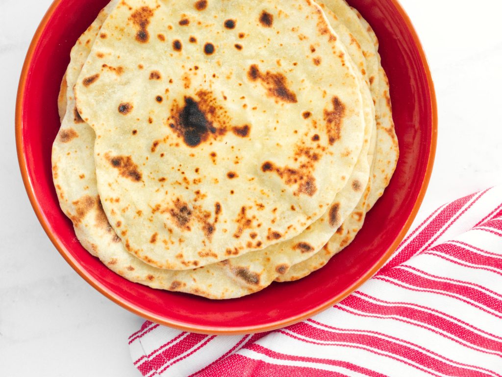 Flatbreads stacked on a red serving plate