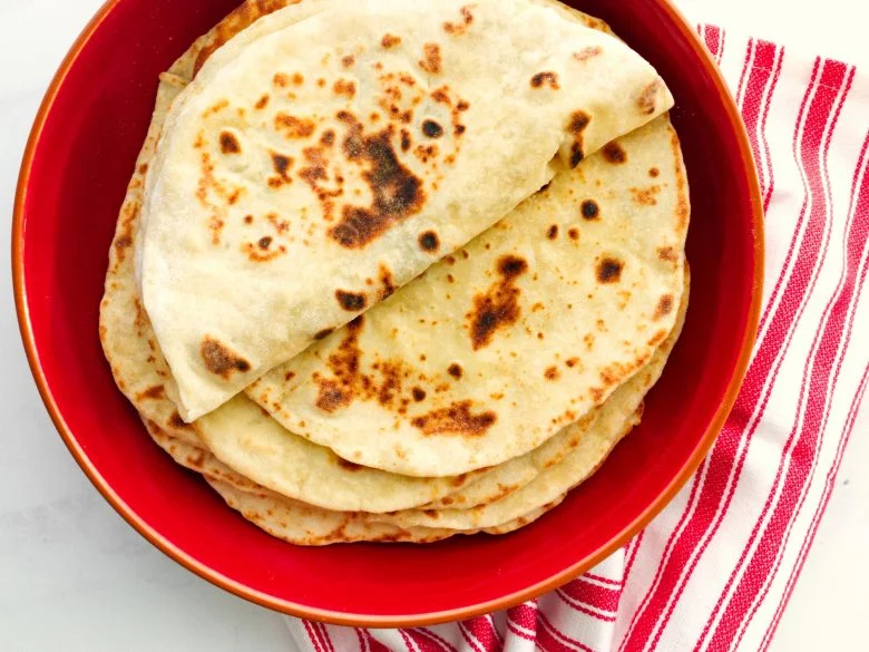 A stack of flatbreads on a red plate